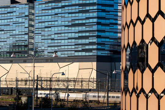 Urban transport infrastructure and cityscape meet in stockholm as commuter train follows railway tracks beneath skyline lines and modern towers