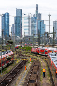 Urban transport infrastructure and network converge at depot where train meets railway tracks as frankfurt skyline lines the horizon
