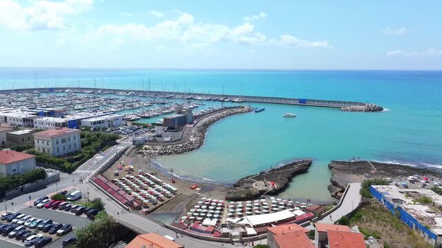 beach sunbathing and yacht club in aerial panorama of port city, Castiglioncello, Italy, historical coastal enclave