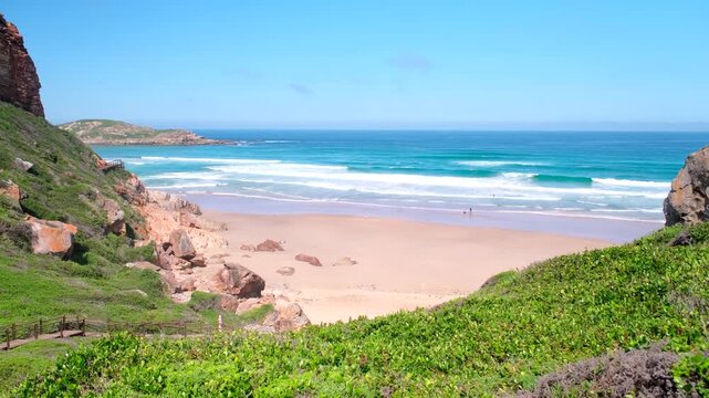 Scenic view over pristine beach toward The Island at Robberg Nature and Marine Reserve as waves crash, Plettenberg Bay, South Africa