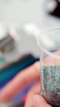 Plastic granules of polycarbonate or plexiglass in hand - extrusion manufactory