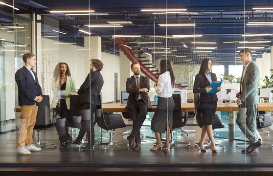 Business people team meeting discussion in office. Colleagues networking in a modern workspace, sharing ideas and planning. Preparing for seminar workshop. Clear teamwork and unity concept.