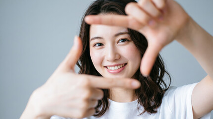 Fototapeta premium 指で四角形のフレームを作る若い女性のポートレート