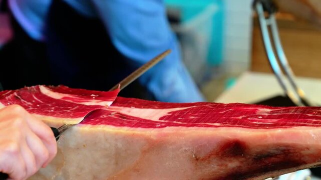 Chef cutting dry-cured spanish ham Jamon.
