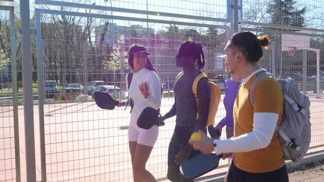 Diverse group of friends walking to a pickleball court
