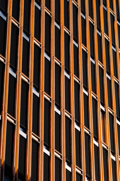 Orange metal surfaces bring texture to a modern architecture facade where grid lines and abstract pattern create bold geometric depth