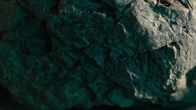 Close-up rock surface with green tones and cracked rugged texture