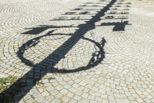 Schatten eines Maibaums auf Kopfsteinpflaster am Marktplatz in Dettingen an der Erms
