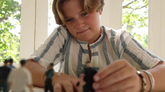 12 year old boy playing with toy figures at home