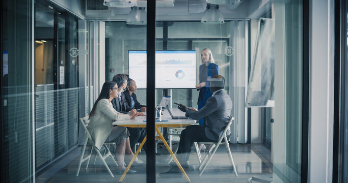 Business Team Meets in a Glass Conference Room to Review Digital Dashboards, Discuss Performance Metrics, Align Strategy, and Plan Key Projects, Focusing on Revenue Growth, Customer Results