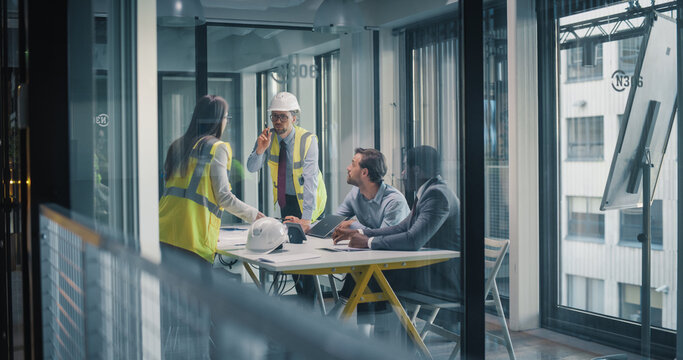 Construction and Business Leaders Meet in a Glass Office to Plan Site Work, Review Drawings, Coordinate Schedule and Budget, Discuss Safety Procedures, and Align Project Milestones