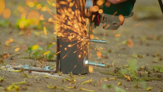 Power tool grinding metal fastener flush with bracket surface on installed structure close perspective. Continuous spark emission during cutting operation refining assembly alignment. Building