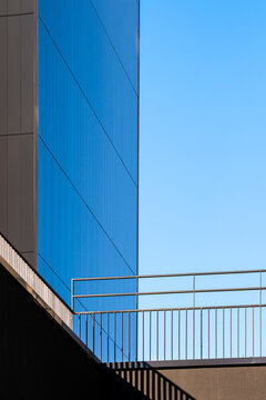 Geometric lines and railing detail on modern minimal architecture facade stand against blue sky creating clean contemporary background for layouts