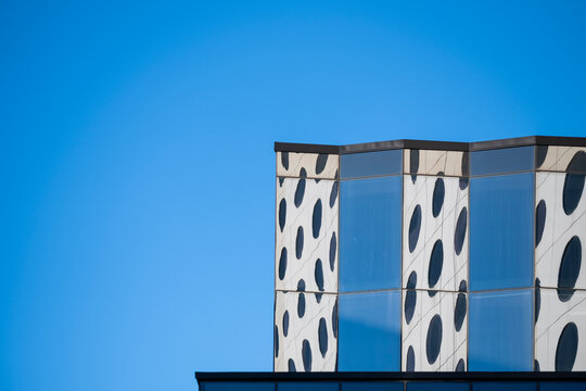 Geometric rooftop detail in modern minimal architecture facade shows blue sky pattern creating clean abstract design backdrop for graphics
