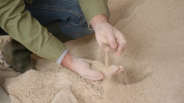 Closeup of handful of maize meal in hands of male farm worker. Concept of energy rich natural animal feed