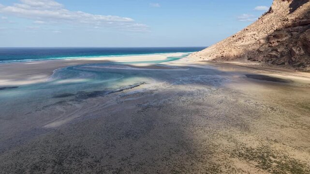 Turquoise lagoon and sandbars beside rocky coastal cliff. Detwah Lagoon, Sokotra, Yemen.
