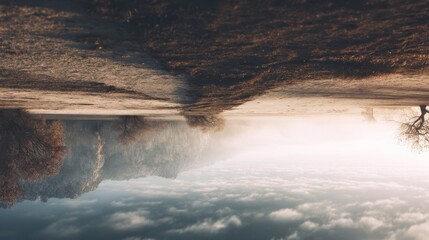 Naklejka premium Dreamlike mirrored landscape with mountains, clouds, and earthy field tones