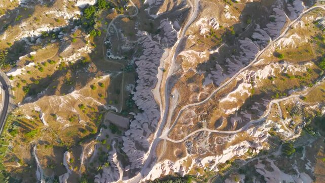 Uchisar, Nevsehir, Turkey. Aerial view showing transportation arteries of asphalt and dirt roads connecting valleys across Cappadocia plateau with scattered trees.. Aerial View, HEAD OVER SHOT