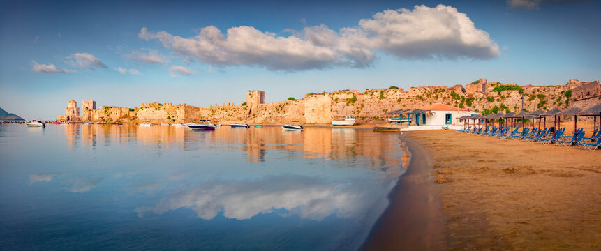Panoramic summer view of Methonis beach with Methoni Castle on background. Calm morning seascape of Ionian sea, Peloponnese peninsula, Greece, Europe. Traveling concept background.