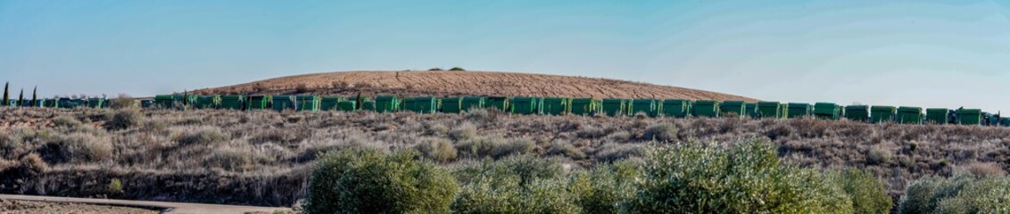 Long row of green waste containers in a rural area © JuanFrancisco