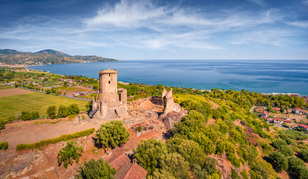 Astonishing summer view of historical landmark - Velia Tower among green field. Impressive morning scene of Parco Archeologico di Velia, Italy, Europe. Traveling concept background.
