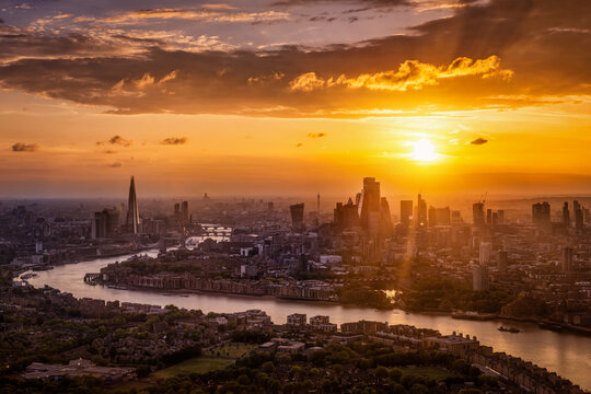 Beautiful summer sunset behind the urban skyline of London, England, with sunlight and cloudscape above the City