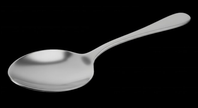A single polished stainless steel tablespoon isolated on a solid black background, angled view showing reflective metallic surface
