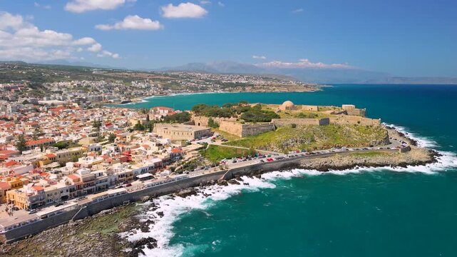 Greece Crete Rethymnon 4K Drone Video Side Flight Along Coast to Fortezza Castle Venetian Fortress with Sea View and Old Town Panorama Travel Destination