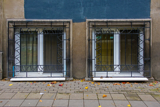 Closed old dirty glass windows with metal fences