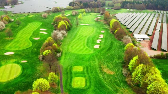 Schr&auml;ger 4K-Drohnen-&Uuml;berflug &uuml;ber einen Golfplatz: Perspektivische Ansicht von Fairways und Gr&uuml;ns.