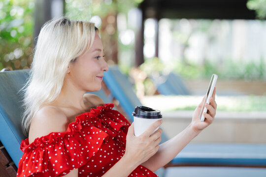 Happy Cheerful smiling Middle aged Caucasian woman using smartphone with positive smile expression for good news