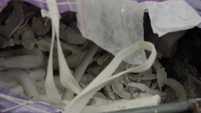 torn and shredded mixed plastic waste material ready for processing at recycling plant