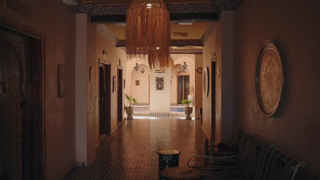 Interior view of a traditional Moroccan riad with tiled floors and carved wooden doors