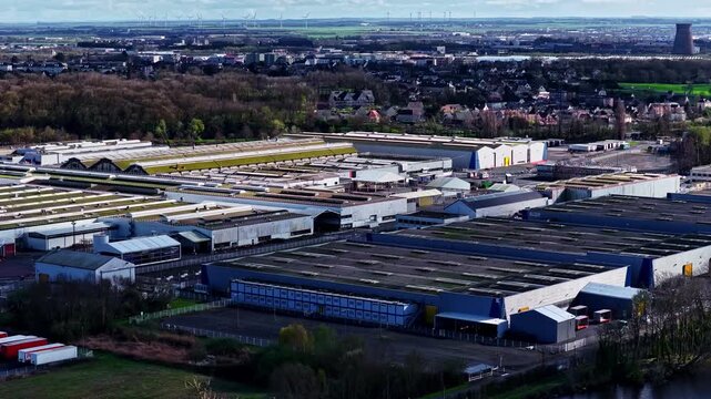 A dense cluster of logistics warehouses and factory sheds spreads across a flat European lowland plain. Renault Factory, France