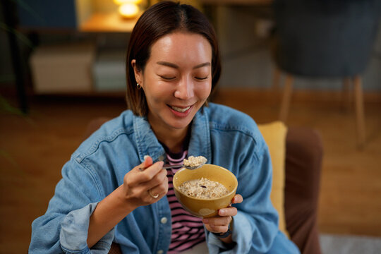 Close up of smiling woman eating oatmeal at home