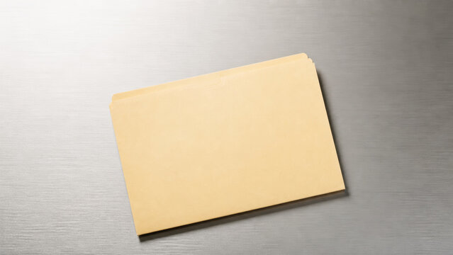 Manila file folder on brushed metal background