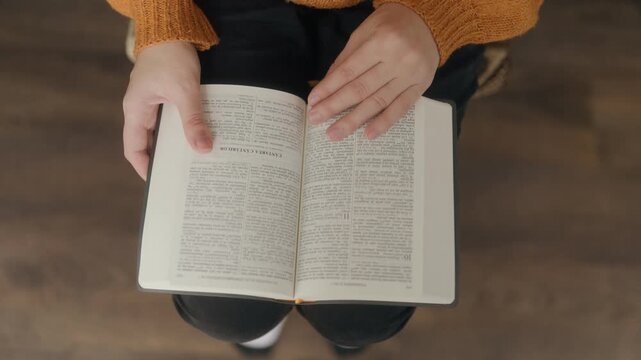 High Angle Close Up One Woman Hands Reading Holy Bible On Lap