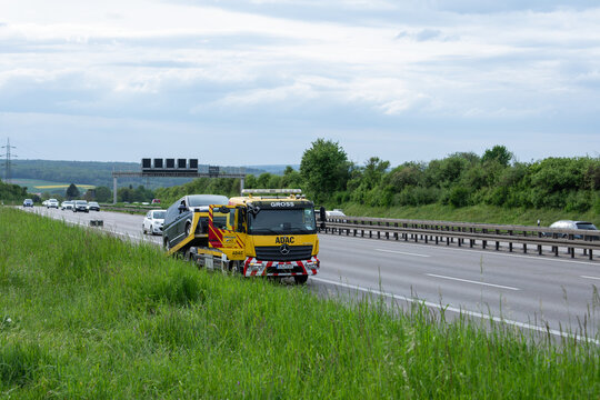 04.05.2026: Yellow ADAC recovery truck (Mercedes-Benz) from company Gross transporting a broken-down car on the shoulder of the A8 motorway. Kirchheim unter Teck, Baden-W&uuml;rttemberg, Germany.