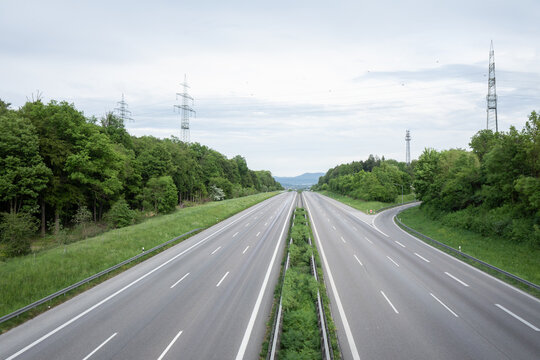 04.05.2026: Elevated wide-angle view of a nearly empty A8 motorway stretching through a green landscape with power lines. Kirchheim unter Teck, Baden-W&uuml;rttemberg, Germany.