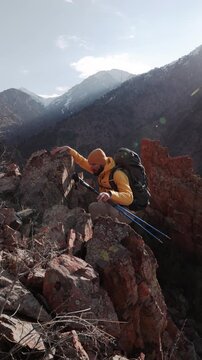 Solo mountain traveler climbing rugged rocky cliff showing strength resilience healthy lifestyle outdoor adventure wanderlust motivation mindful ascent nature escape alpine terrain travel inspiration