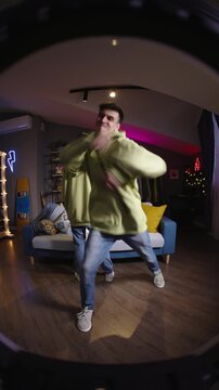 Gen z teen couple dancing in hoodies filming vertical video at home for social media creator economy youth culture trends