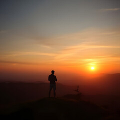 Fototapeta premium silhouette of a man standing on a mountain top