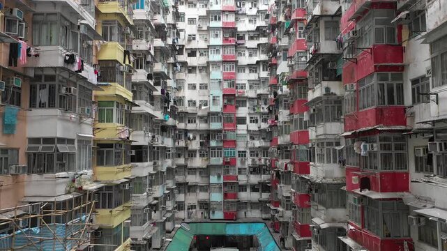 Hong Kong housing crisis and poverty - Abstract retreating drone shot through narrow claustrophobic apartment complex in Quarry Bay district