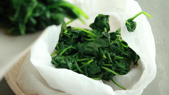 Close-up of draining cooked spinach using a colander to remove excess water