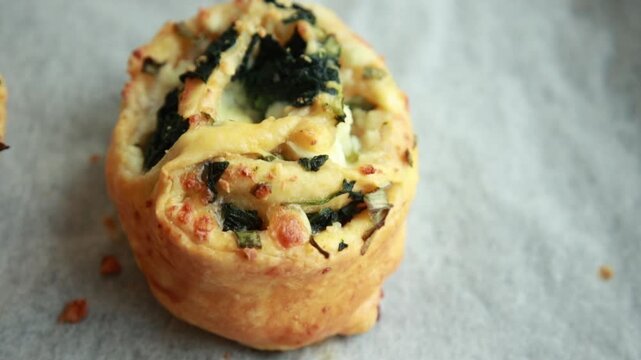 Freshly baked golden puff pastry appetizers with spinach and cheese on a baking tray