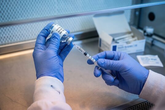 gloved hands drawing feline NSAID vial with syringe sterile compounding pharmacy