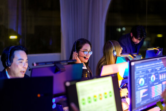 Serious female developer monitoring global network status and system security. Dedicated technical consultant reviewing cloud native solutions and digital infrastructure under blue neon light.