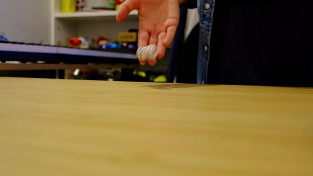 Low angle closeup shows a hand tossing dice across a wooden table, motion blur and shallow focus building suspense. Board games spark family bonding and teach risk, choice, and probability.