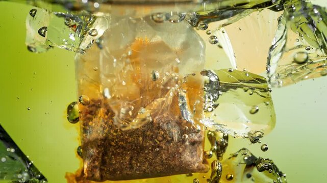Super Slow Motion of Falling and Extracting Tea Bag into Water with Ice at 1000fps, Ice Tea Concept.
