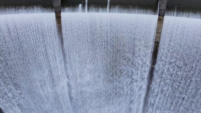 Powerful Water Cascade Through Concrete Spillway Of Encoro do Eume Dam In Galicia, Spain. close-up, ascending drone shot
